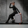 Gray hard-shell check-in suitcase with telescopic handle and red wheels