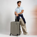 Dark green medium check-in suitcase with four wheels and telescopic handle