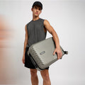Small cabin suitcase in light grey with ribbed shell and side handle on wheels