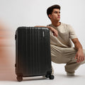 Charcoal grey check-in suitcase with telescopic handle and 8 spinner wheels.