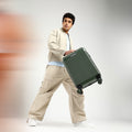 Dark green hard-shell check-in suitcase with telescopic handle and 8 spinner wheels