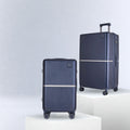 Dark blue hard-shell trolley luggage set with upright handles and spinner wheels