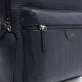 Black textured leather backpack side zipper pocket with pull tab and inner compartment
