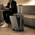 Dark grey cabin trolley with front-access laptop compartment and spinner wheels