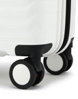 White cabin suitcase with black wheel housing and smooth rolling wheel close-up