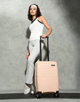Small cabin suitcase in peach with telescopic handle and 8 spinner wheels