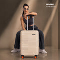 Beige hard-shell trolley suitcase with upright handle and 8-wheel spinner stand