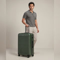 Medium check-in suitcase, dark green hard shell with 8 spinner wheels, upright handle