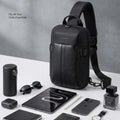 Black nylon crossbody sling bag with top handle, front pocket, and slim profile.