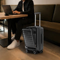 Black hardshell cabin trolley with 8 spinner wheels shown beside a seated traveler