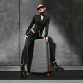 Hard-shell luggage set of 2 with 8 wheels, dark and grey cases standing on caster wheels.