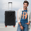 Black hard-shell check-in suitcase with telescopic handle and red wheel accents