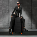 Black hard-shell spinner luggage with extended handle and 8 wheels beside model.