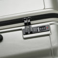 Silver suitcase close-up: zipper track and control panel with lock buttons