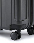 Small cabin suitcase with 4-wheel base, dark charcoal grey shell, and corner bumper.