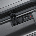 Charcoal grey suitcase with zip closure and built-in combination lock panel detail.