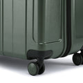Dark green hard-shell suitcase corner with black 8-wheel base and latch