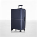 Hard-shell polycarbonate trolley luggage, dark blue, back view with telescoping handle and wheels