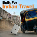 White cabin suitcase with four wheels and textured front, near a parked auto