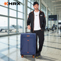 Blue HRX soft-body spinner trolley with front logo, telescopic handle, and orange wheels