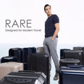 Hard-shell trolley suitcase with dark blue case among multiple suitcases