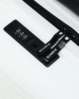 Black TSA-style combination lock and zipper pull on a white suitcase