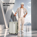 Silver check-in suitcase with upright handle and spinner wheels, shown with traveler