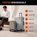Silver upright trolley suitcase with front panel and spinner wheels on test display