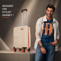 Beige small cabin suitcase upright with telescopic handle and orange spinner wheels