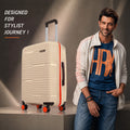 Beige medium check-in suitcase with upright handle, orange edge trim, and 4 spinner wheels.