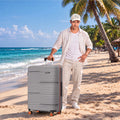 Grey hard-shell rolling suitcase with orange wheels and extended handle