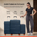 Two-piece hard-shell luggage set with telescopic handles and orange wheels, on floor