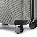Silver small cabin suitcase close-up of side wheels and ridged shell with dark base