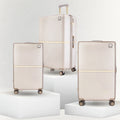 Beige hard-shell polycarbonate trolley suitcase set with extended handle and roller wheels.