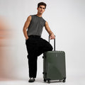 Dark green ribbed hard-shell suitcase on 8 wheels with extended telescopic handle