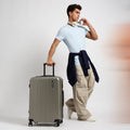 Medium check-in suitcase in dark green with telescopic handle and four wheels