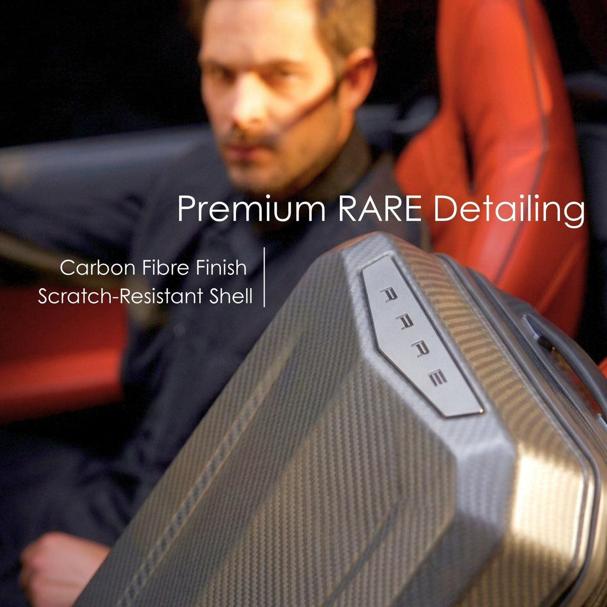 Dark hard-shell suitcase with carbon-fiber style finish and metal badge on top