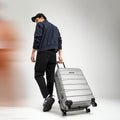 Large check-in suitcase with telescopic handle and spinner wheels, light silver-gray