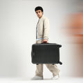 Dark charcoal hard-shell check-in suitcase with telescopic handle and 8 spinner wheels