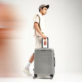 Light silver hard-shell check-in suitcase with telescopic handle and 8 spinner wheels