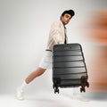Large hard-shell check-in suitcase in dark gray/black with 8 wheels, front view.