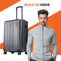 Charcoal grey medium check-in suitcase beside a standing man with a zip jacket
