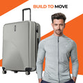 Silver ribbed check-in suitcase with upright handle and four caster wheels.