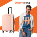 Peach small cabin suitcase with extendable handle and 8 spinner wheels.