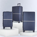 Three dark blue hard-shell trolley suitcases on pedestal blocks, with spinner wheels