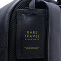Leather travel backpack with front slip pocket and woven black textured panel