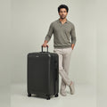 Large check-in polycarbonate suitcase, dark charcoal ridged shell, spinner wheels