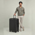 Medium check-in suitcase, dark hard shell with 8 spinner wheels, side handle and lock