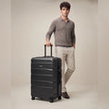 Black polycarbonate medium check-in suitcase with 8 wheels, side vents, and telescopic handle