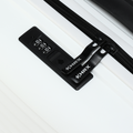 Black TSA-style lock and zipper track on white suitcase, close-up